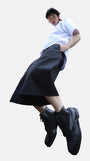 Homme en mouvement portant le bermuda Shaka noir, coupe ample inspirée du hakama japonais, associé à un t-shirt blanc et des boots noires