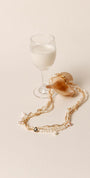 Collier multi-rangs en perles de culture blanches et rosées, orné de cristaux Swarovski et monté sur chaîne plaqué or.