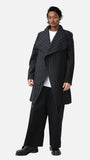 Homme portant un manteau Koto croisé à rayures, non doublé, confectionné en lainage upcyclé avec fermeture magnétique invisible et coupe oversize