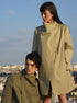 Homme et femme portant le manteau Koto croisé, non doublé, fabriqué à partir de matières upcyclées, avec col asymétrique et fermeture magnétique