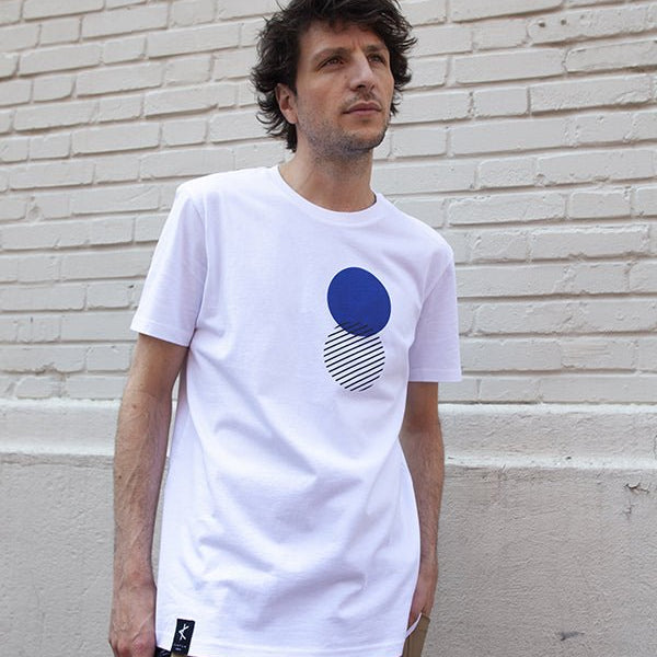 Homme portant un t-shirt blanc en coton bio avec imprimé graphique bleu sérigraphié, série limitée produite localement