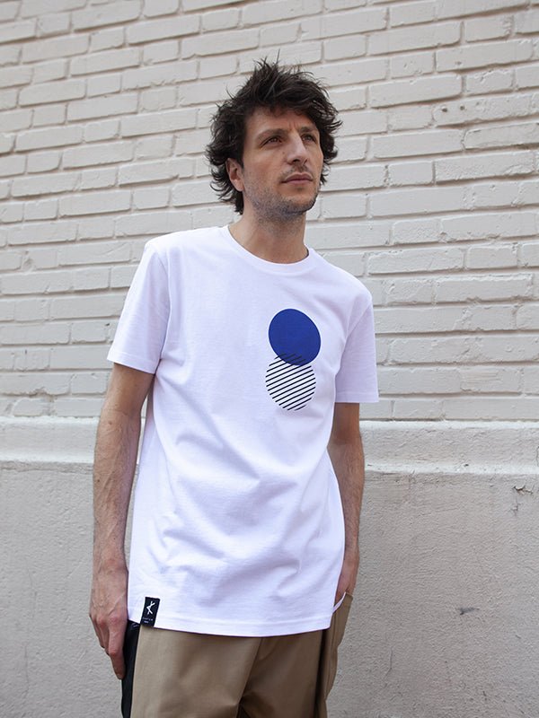 Homme portant un t-shirt blanc en coton bio avec imprimé graphique bleu sérigraphié, série limitée produite localement