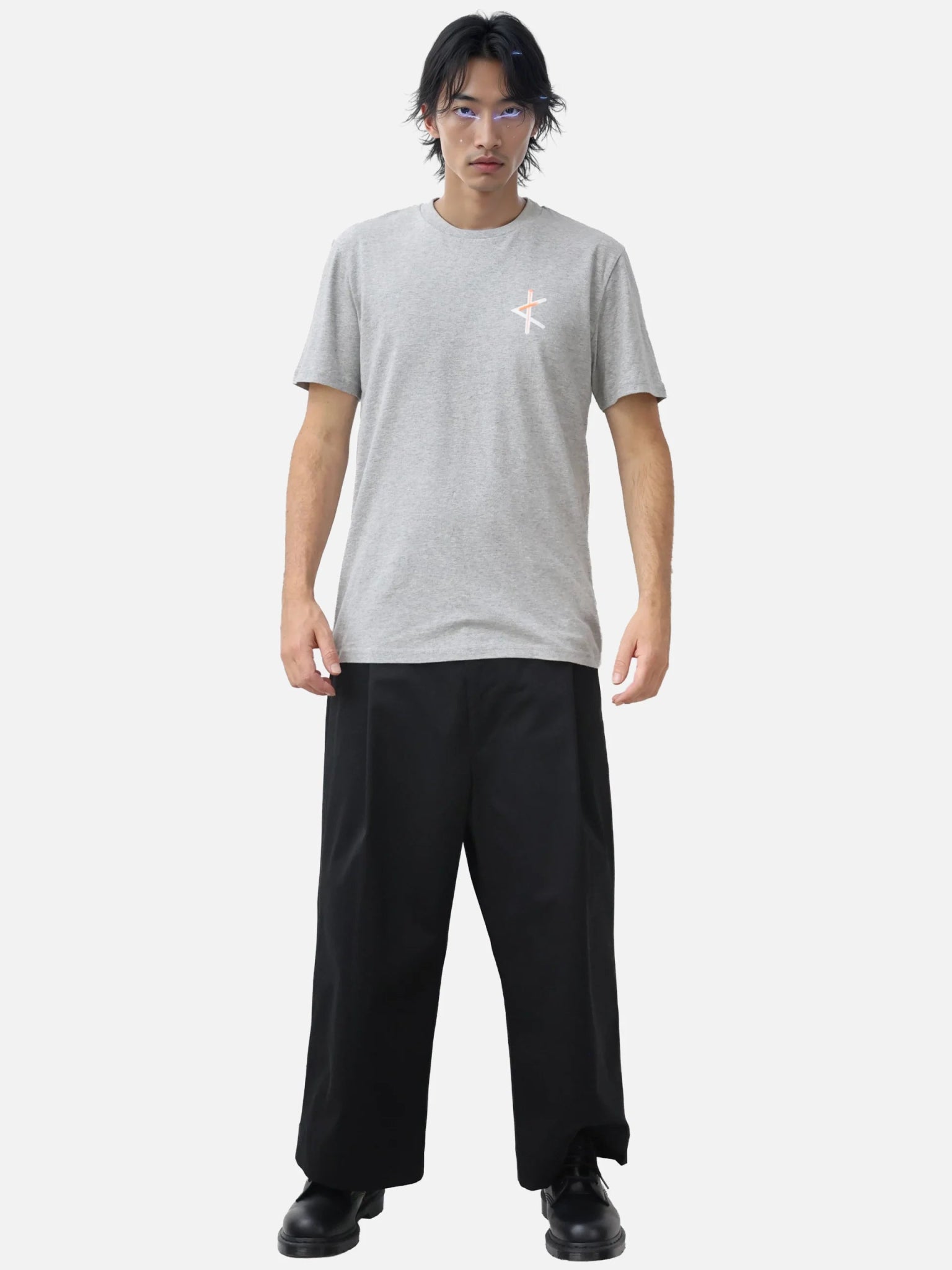 Homme portant un t-shirt gris en coton bio avec logo sérigraphié sur la poitrine, coupe droite et minimaliste, série limitée design local